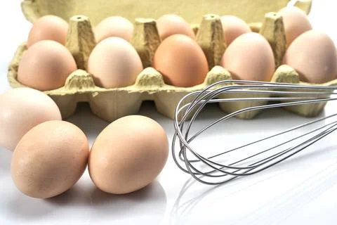 Close-up of eggs in cartoon on white background. Raw chicken eggs in egg box  Stock-Fotos