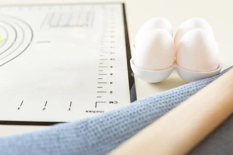 Close-up of eggs, kitchen towel, rolling pin and silicone baking mat on the Stock Photos