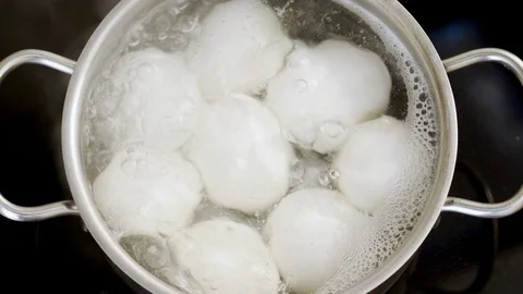 Close-up of eight white chicken eggs in a pan of boiling water. 4K Video stock 122981228