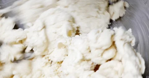 Close-up of elastic dough for bread and/or pizza in a home-made dough mixer.  Video stock 219886457