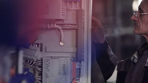 Close-up of elder factory worker opening electric meter. Видео 77106823