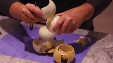 Close up of elder woman's hands cutting an onion on countertop Stock Footage 147987665