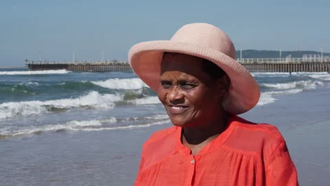 Close-up of an elderly African woman's face as she walks on the beach Stock Footage 242679955