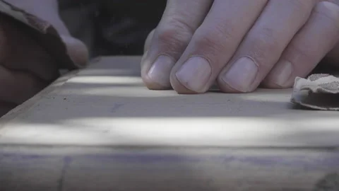 Close up of elderly craftsman hand sanding corner of wooden furniture Video stock 140292407
