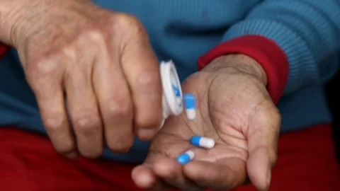 Close up of elderly female taking pills out of medicine pill box Stock Footage 108542525