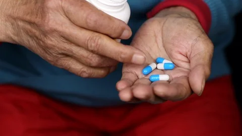 Close up of elderly female taking pills out of medicine pill box Stock Footage 108543101