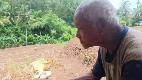 Close-up of an elderly Indonesian farmer taking a break. Stock Footage 321932963