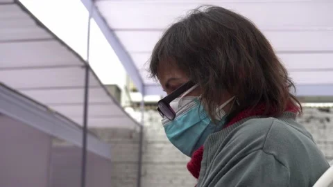 Close-up of an elderly lady wearing double mask with glasses resting after Vidéo 156307264