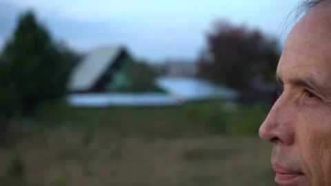 Close-up of an elderly lonely man looking thoughtfully at the summer sunset Stock Footage 139674912