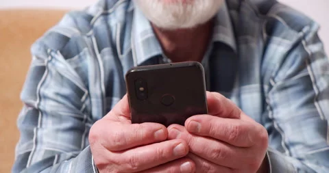 Close-up of an elderly male hands holding a smartphone while typing a message Stock Footage 146727331