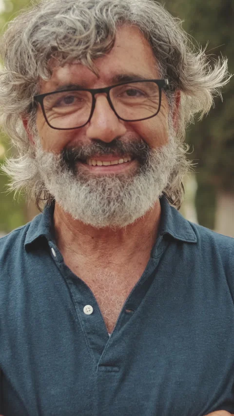 Close-up of an elderly man crossing his arms and looking at the camera with Stock Footage 252504034