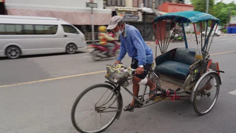 Close Up Of An Elderly Man Riding Bicycle Taxi Rickshaw In Traffic On Road Stock Footage 260187344