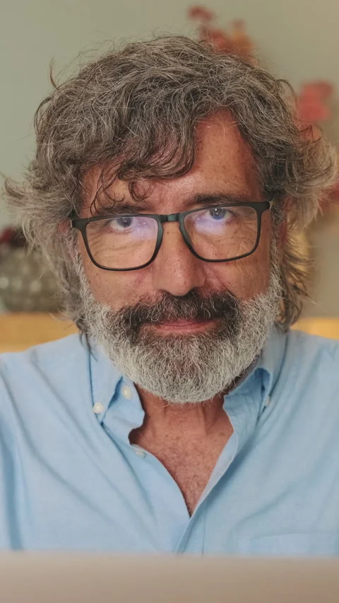 Close-up of an elderly man sitting in living-room with laptop looking at the Stock Footage 252207283