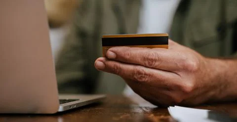 Close up elderly man using credit card to make online payment Stock Photos