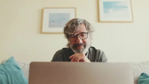 Close up, elderly man working on laptop sitting on the sofa in the living room Stock Footage 229506861