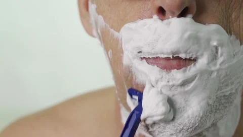 Close-up of an elderly man's chin shaving with a disposable razor Stock Footage 164543015