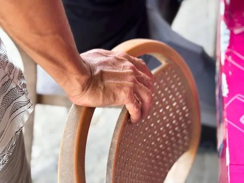 Close up of an Elderly Man's Hand Grasping the Back of a Wooden Rattan Chair Stock-Fotos