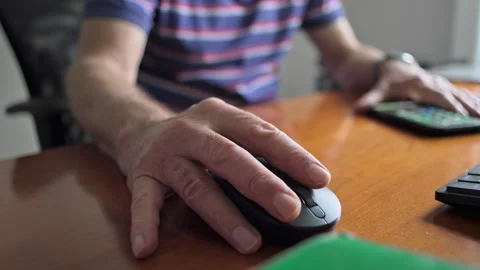 Close-Up Of Elderly Mans Hand Moving Computer Mouse Across Wooden Desk Surf.. Stock Footage 320959745