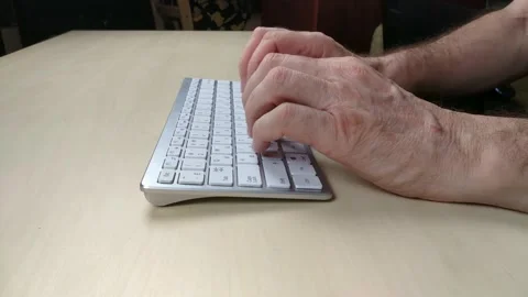 Close-up of an elderly man's hands are typing on a white keyboard Stock Footage 147213672