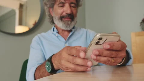 Close-up of an elderly man's hands sending text messages from mobile phone, Stock Footage 252502433