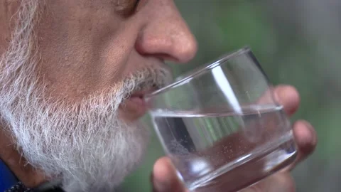 Close-up of an elderly man's swallows a pill drinks water Stock Footage 235945401