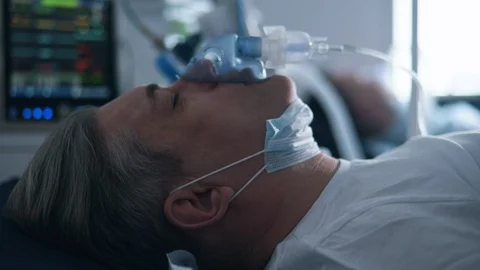 Close up of elderly patient's face with an oxygen mask on it. COVID 19, virus Stock Footage 128224072
