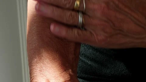 Close up of an elderly person applying moisturizing cream or sunscreen to their 库存影片 333478593