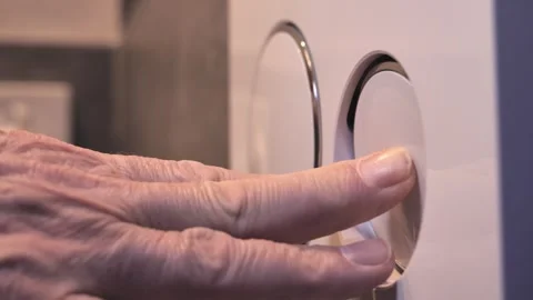 Close up of an elderly person's hand pressing a dual flush button Stock Footage 332272088
