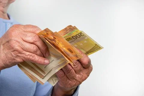 Close-up of an elderly persons hands counting Euro bills Stock Photos