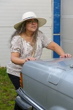 Close-up of an elderly woman with smiling expression on face pushing a car Stock Photos