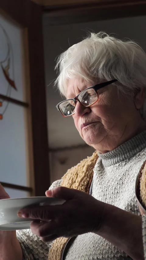 Close-up of an elderly woman who eats porridge. The old woman eats food. Social Stock Footage 270389895