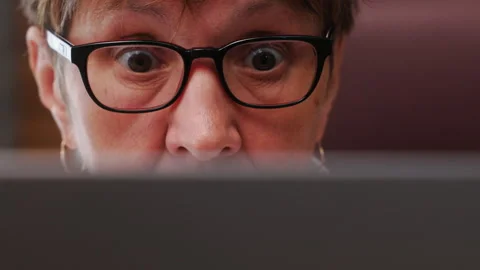 Close-up of elderly woman's face with glasses, focused while looking at computer Stock Footage 282046970
