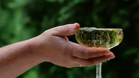 Close-up of an elderly woman's hand taking a glass of white sparkling wine. Stock Footage 162698801