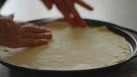 Close-up, elderly woman's hands align pizza dough on a round protwin Stock Footage 174759994