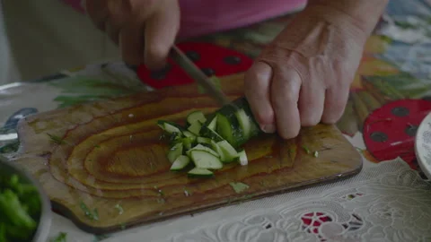 Close-up, Elderly Woman's Hands Cut Fresh Cucumber Knife on Wooden Board Stock Footage 147030931