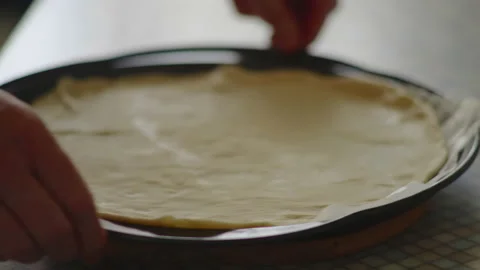 Close-up, elderly woman's hands spread pizza dough on the protwin Stock Footage 172716145
