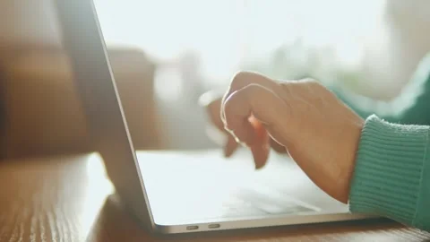 Close-up of an elderly woman's hands typing on a laptop at home. Video stock 243125369