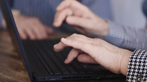 Close-up of an elderly woman's hands typing on a laptop keyboard. Pensioner at Stock Footage 246029421