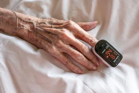Close-up of an elderly women's hand with a pulse oximeter on her finger Stock Photos