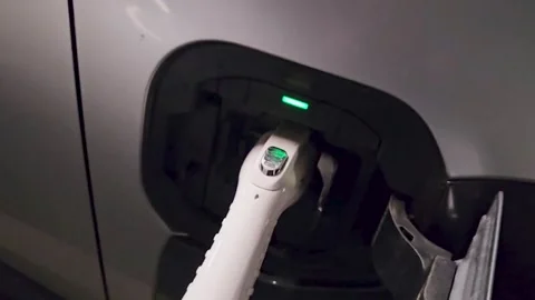 Close-up of an electric car being charged  charging plug connected to the v.. Stock Footage 323114906