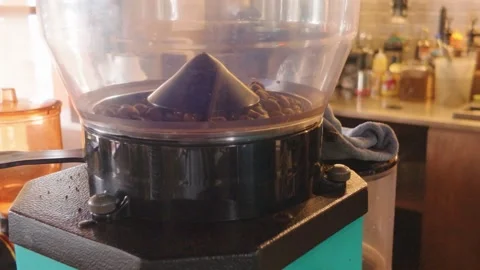 Close up of an electric coffee grinder hopper filled with roasted coffee beans. Video stock 343402042