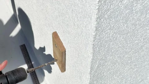 Close-Up of Electric Drill Bit Drilling Through Wooden Board Into Wall Stock Footage 344039575