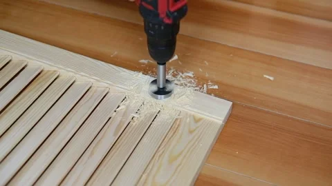 Close-up of electric drill making hole in wooden board. Clean woodworking scene Stock Footage 311755760