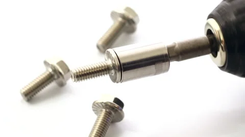 Close-up of an electric drill rotating a block containing a nut Stock Footage 322527716
