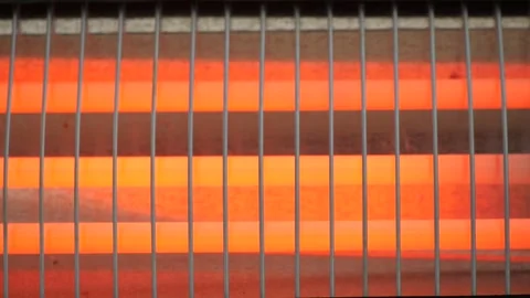 Close up of an electric heater with glowing red heating elements behind a p.. Stock Footage 332471542