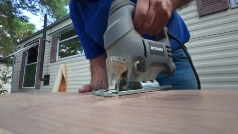 Close-up of electric jigsaw cutting white oak laminate flooring outdoors. Stock Footage 341024614