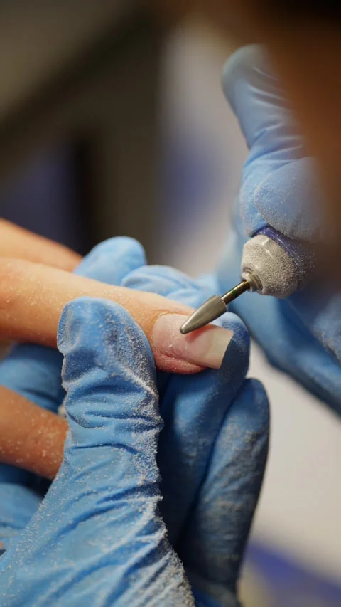 Close-up of an electric nail file working on a nail. 스톡 동영상 343530492