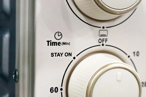 Close up of an electric oven control panel showing a mechanical time dial w.. Stock Photos