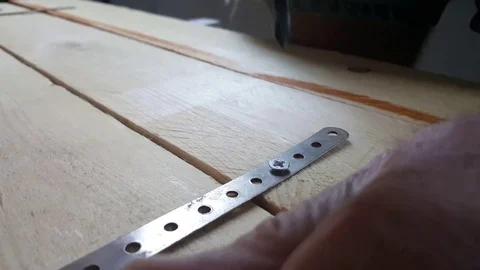 Close up of electric screwdriver screws screw into metal on wooden board Vídeos de archivo 77401296