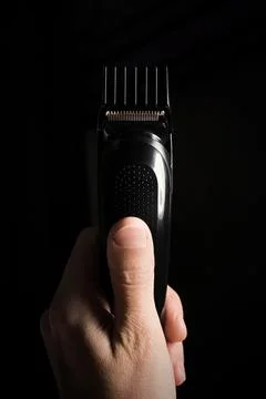 Close-up of Electric shaver machine with nozzle in hand on black background Stock Photos